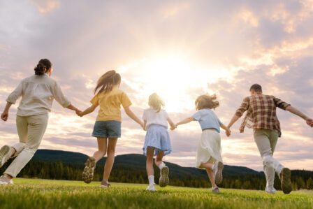 Happy family at sunset Happy family at sunset. Father, mother and children are running, having fun and enjoying summer evening.
